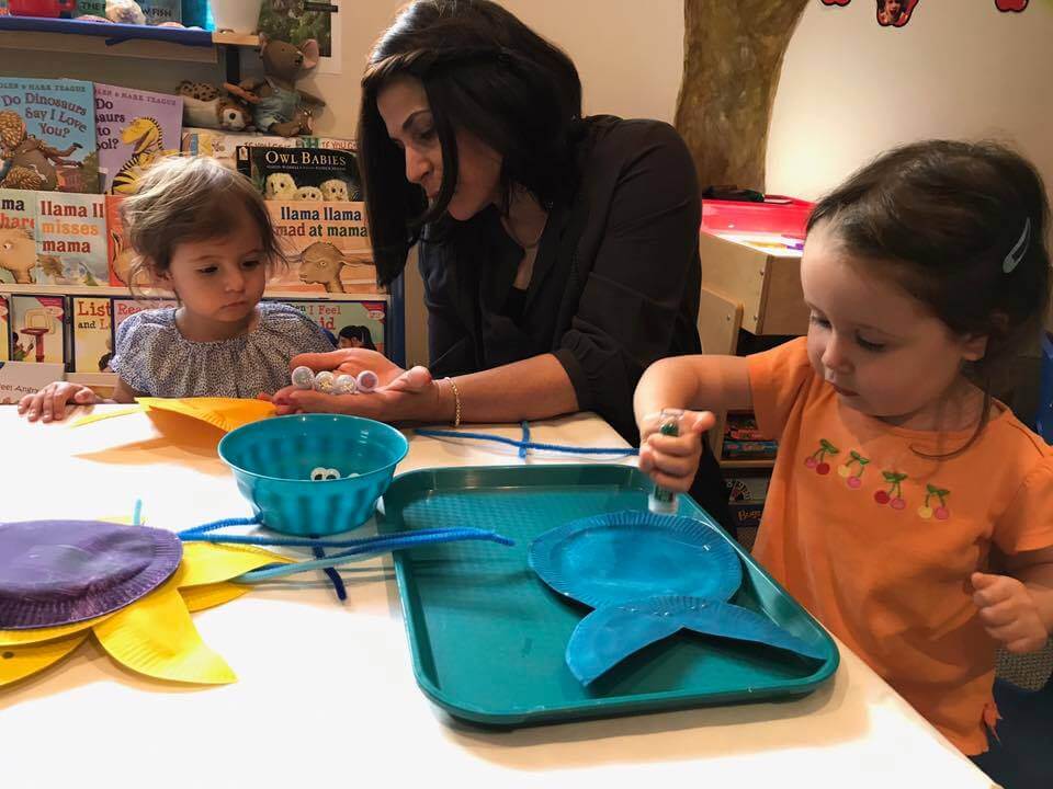 toddler painting fish at Early Childhood Development Associates's class